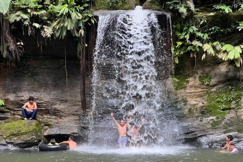 A waterfall, people swimming, and a person raising their hand. 4