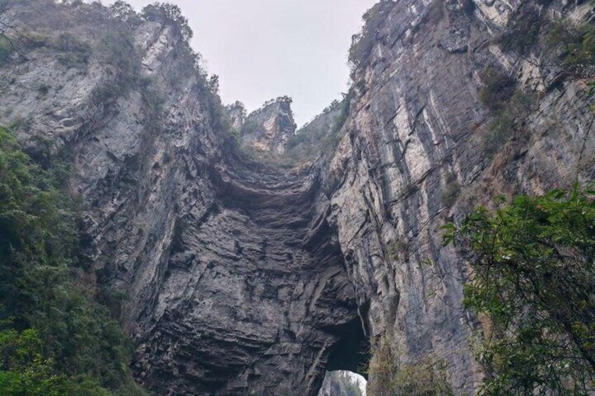 A deep canyon with steep rock walls and sparse vegetation. 4