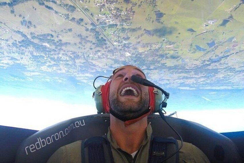 A person in a cockpit with a view of the landscape below. 3
