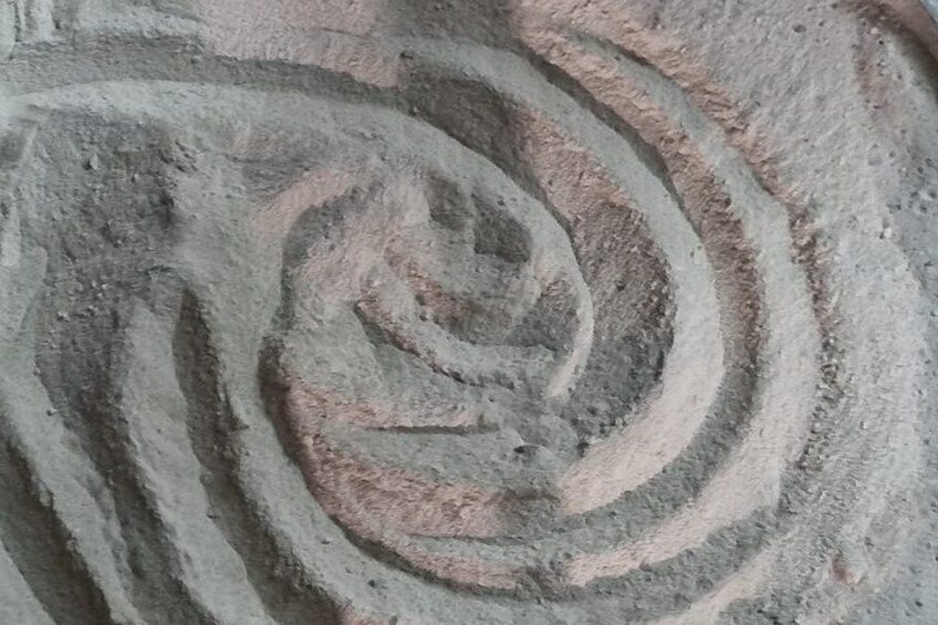 A spiral pattern etched into a stone surface. 3