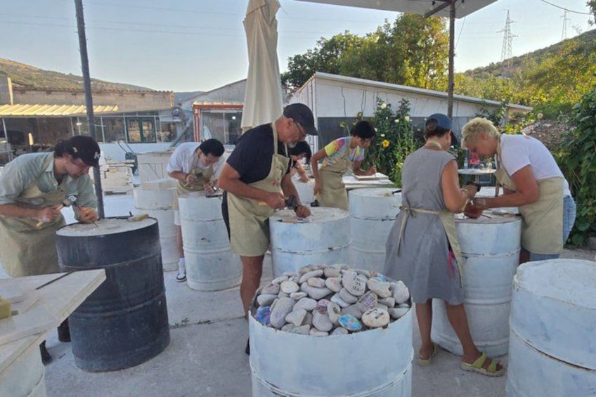 People working with large white barrels outdoors, possibly in a workshop or industrial setting. 5