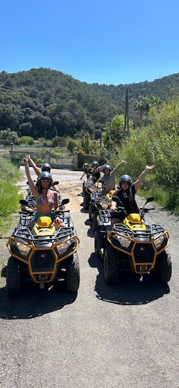 A group of people on ATVs on a road with a hilly landscape in the background. 2