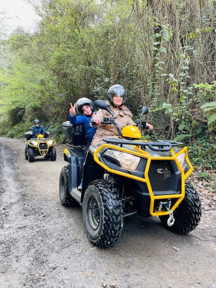 Three off-road vehicles on a dirt path surrounded by dense greenery. 1