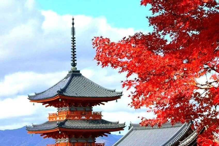 A pagoda with a traditional tiered roof, surrounded by red autumn leaves. 1