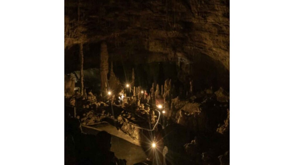 A cave with illuminated structures and stalactites. 5
