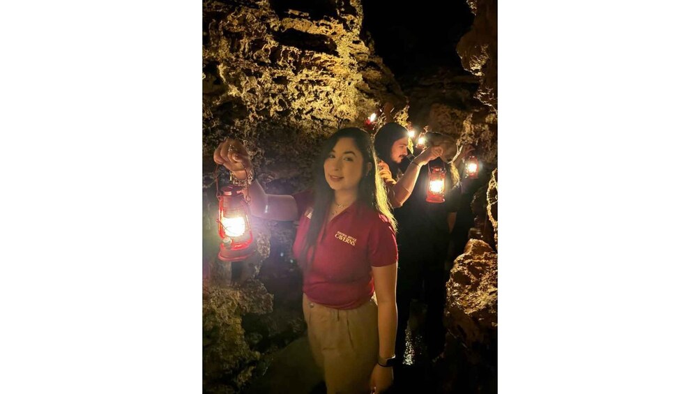 A person standing in a cave with rough, uneven walls and a rocky ceiling. 4
