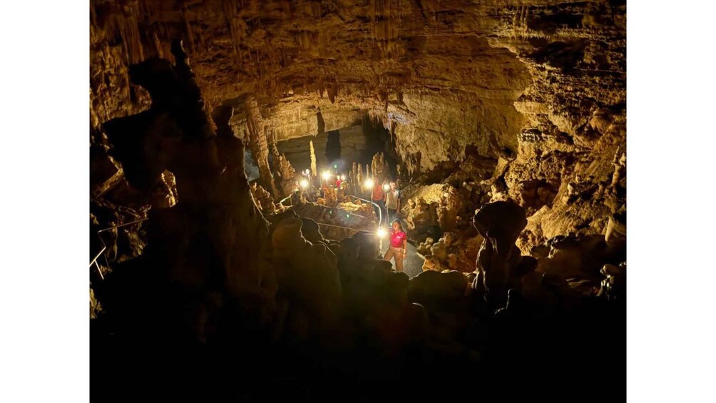 A group of people exploring a cave with artificial lighting. 2