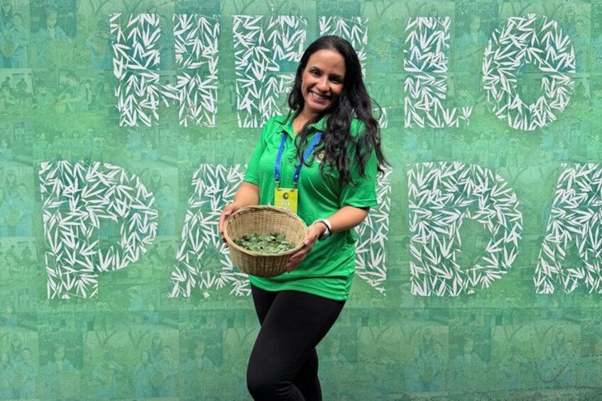 A person holding a basket in front of a wall with leaf patterns. 4