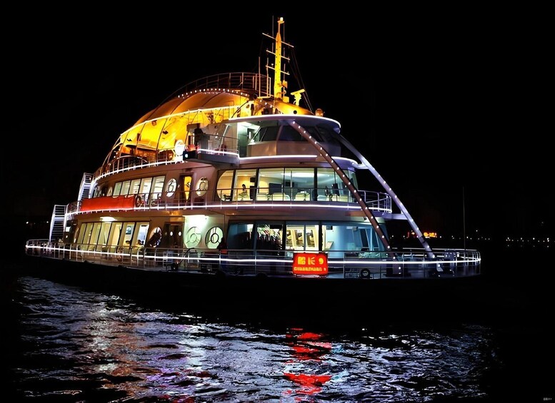 A large, illuminated cruise ship with multiple decks and a prominent funnel. 1