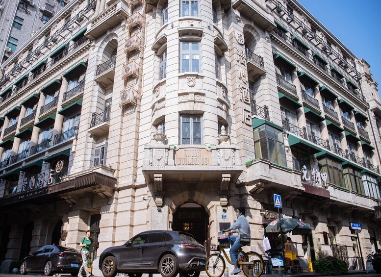 A historic building with ornate architecture, a bicycle parked in front, and a car parked on the street. 5
