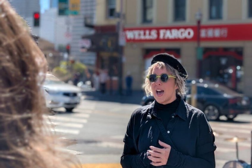 A person standing on a street with a Wells Fargo sign in the background. 2
