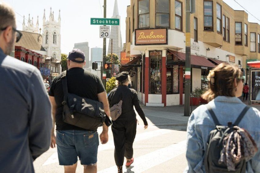 Pedestrians on a city street, a church, and a bar named Barbara. 1