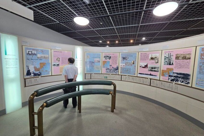 A museum interior with informational posters on the walls and a person standing in front of them. 5