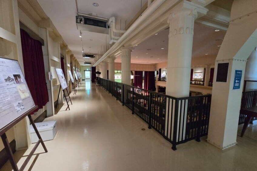 A corridor with display boards, columns, and a railing. 2