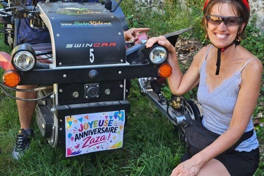 A person sitting on a motorcycle with a 'Swincar' logo and a '5' badge, and a 'Joyeuse Anniversaire Zaza!' sign. 2