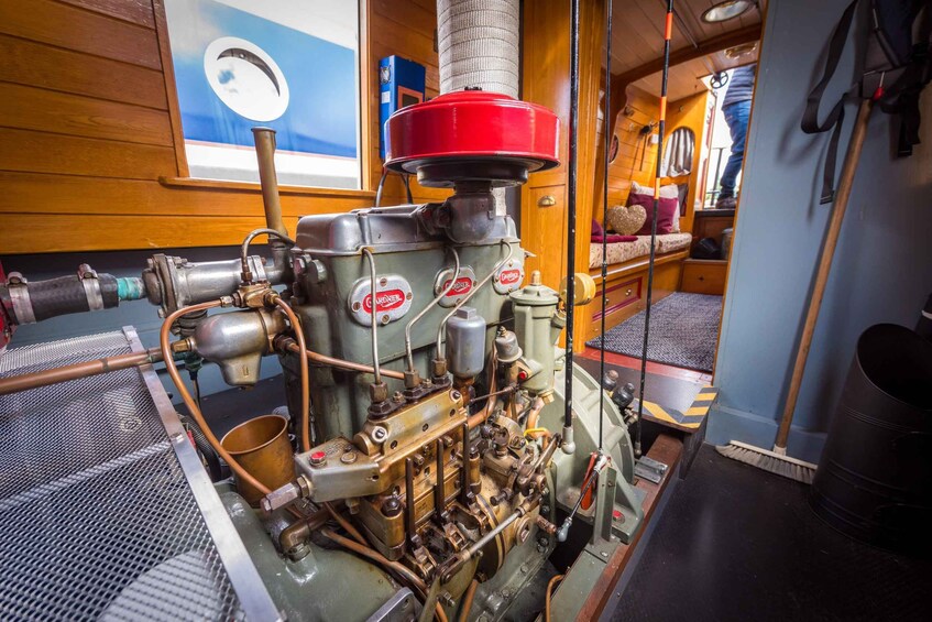 A vintage engine with visible pipes and gauges, set in a room with wooden walls and a window. 5