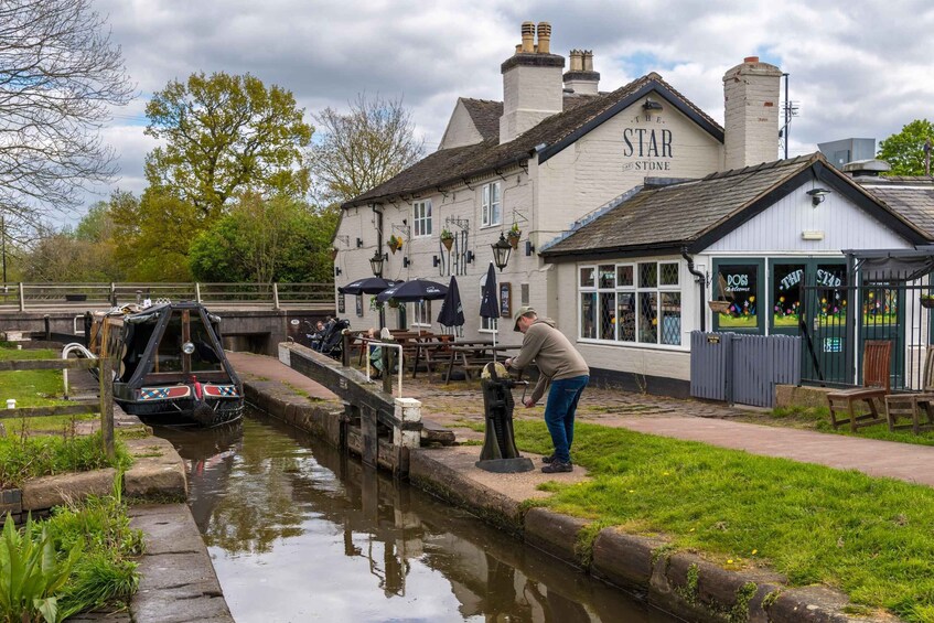 A canal with a narrowboat, a pub named 'The Star', and a person working on a water pump. 3