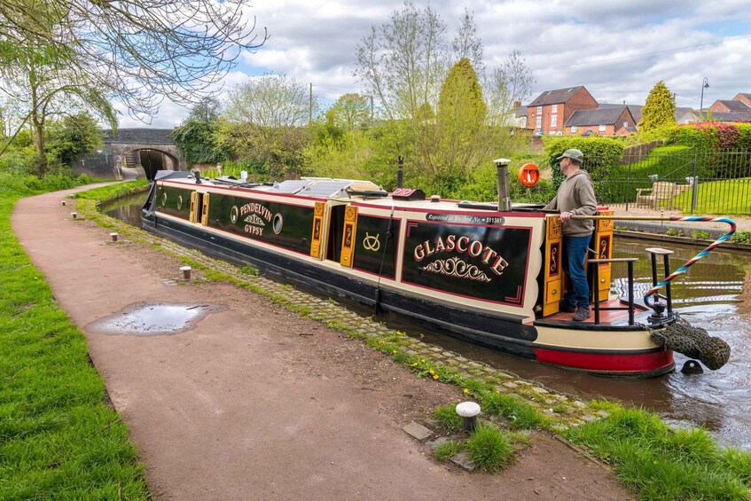 A narrowboat named 'Pen Delvin' docked at a canal, with a person standing on the deck. 2