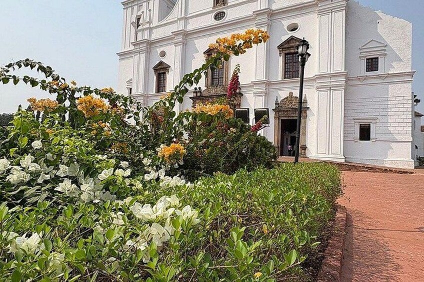 A white colonial-style building with a red brick pathway leading to it. 2
