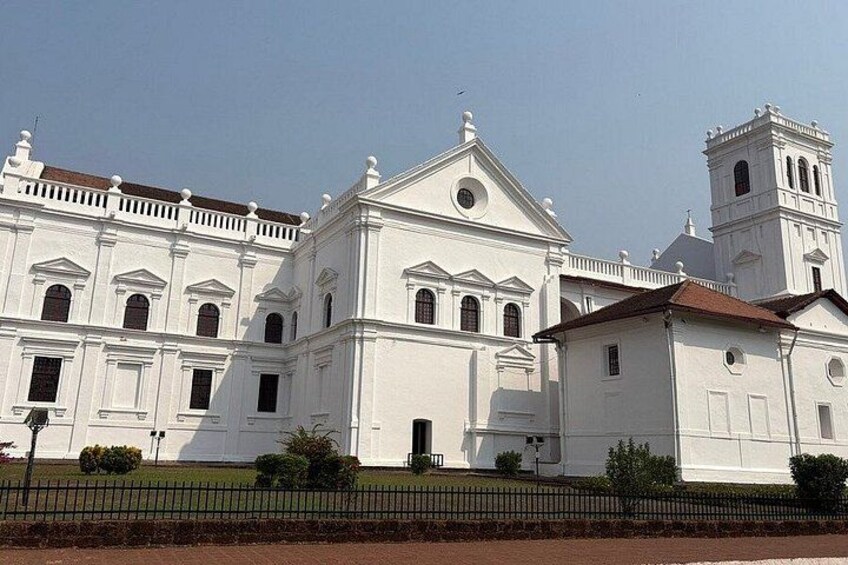 A large white colonial-style building with a bell tower and multiple windows. 3
