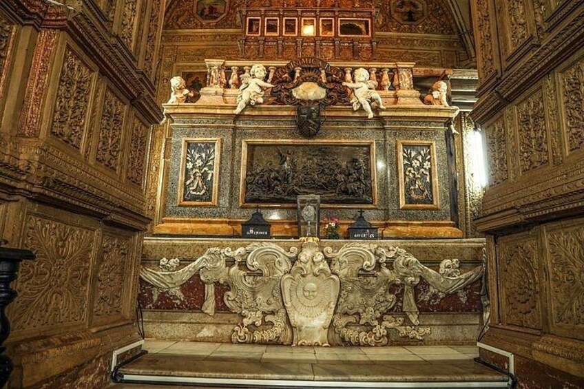 An ornate altar with intricate carvings and statues, surrounded by detailed wall decorations. 5