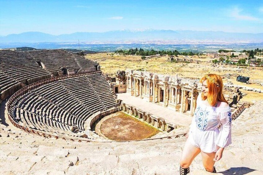 An ancient amphitheater with ruins and a person standing in the foreground. 3