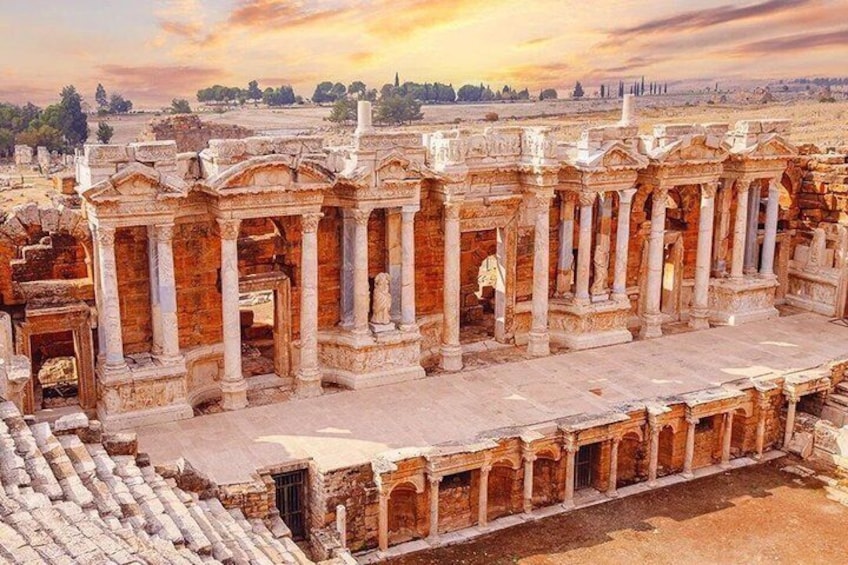 Ancient ruins with columns and arches, a paved walkway, and a distant view of a cityscape. 2