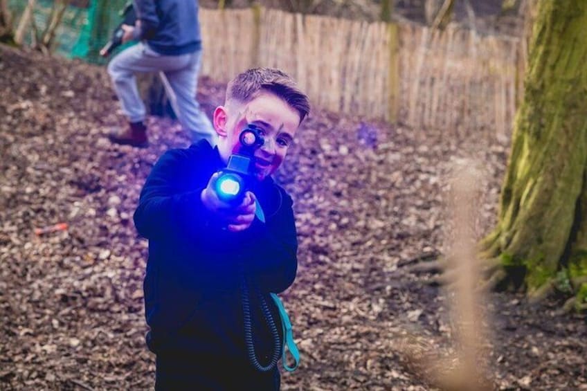 A person holding a flashlight in a wooded area. 3