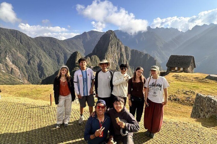 A group of people standing on a cobblestone path with a mountainous landscape in the background. 4