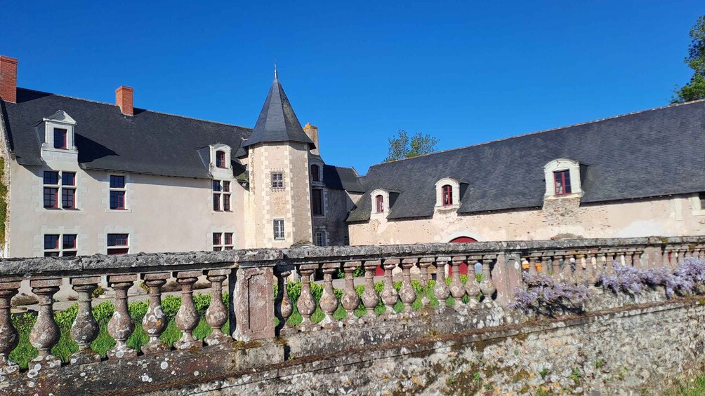 A historic building with a tower, stone balustrade, and a clear blue sky. 1