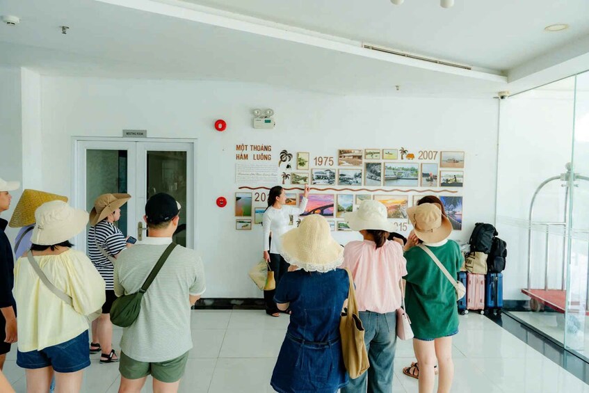 A group of people in a hallway with a wall displaying a timeline of events from 1975 to 2007. 2