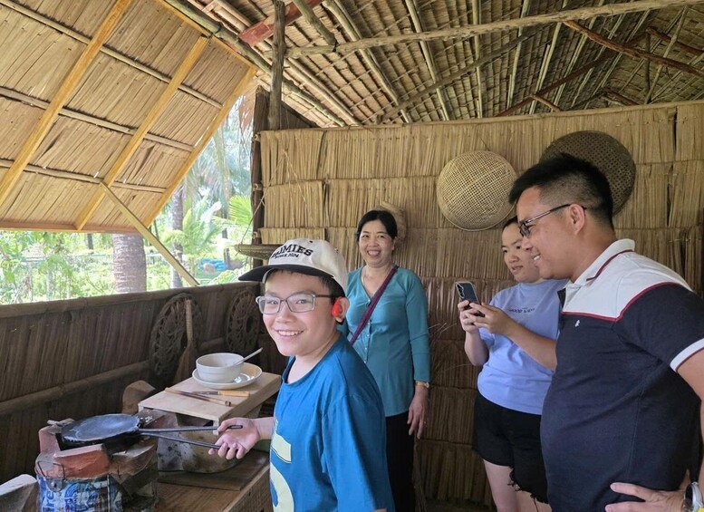 A rustic outdoor setting with a thatched roof, a cooking area with a pot and utensils, and a woven basket. 4