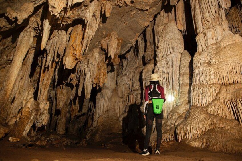 A person standing in a cave with stalactites. 2