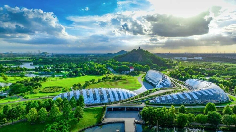 A green landscape with a large dome-shaped building and a smaller dome-shaped building. 4
