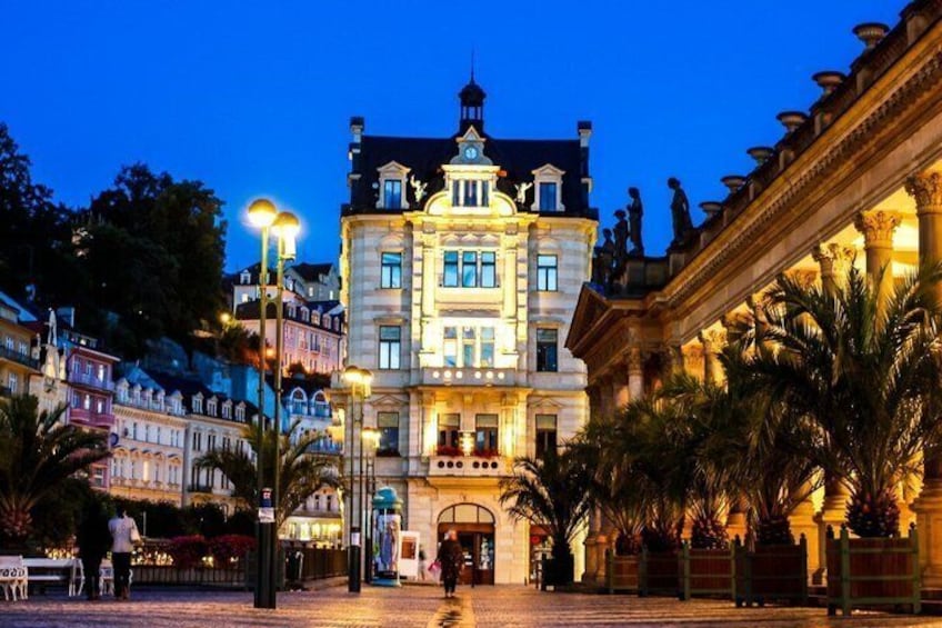 A historic building with ornate architecture, a well-lit plaza, and palm trees. 5