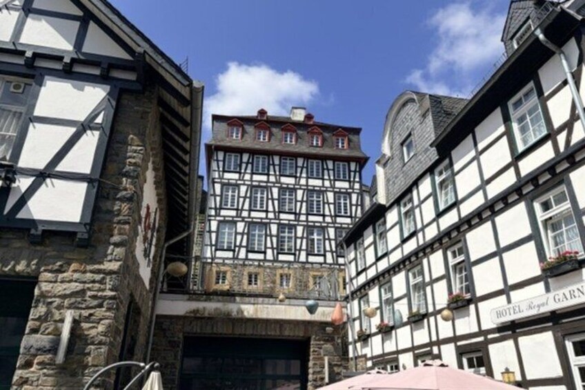 A traditional half-timbered building with a stone facade and a sign for 'Hotel Regis Garni.' 4