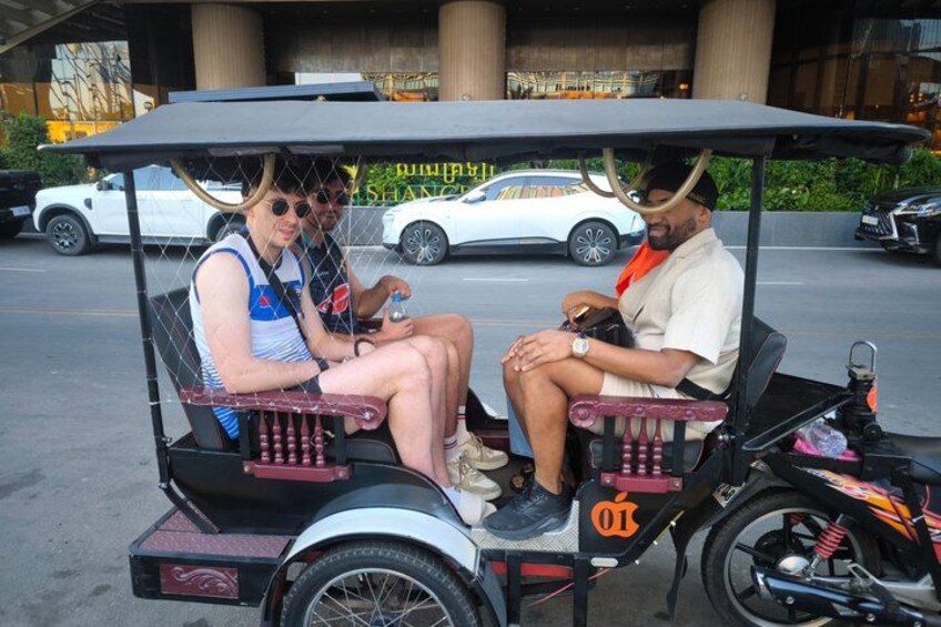 A couple in a cart with a motorcycle parked behind them. 3
