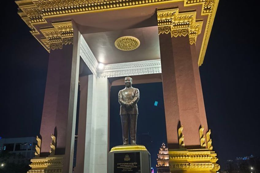 A statue under a golden canopy at night. 4