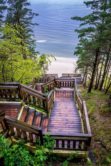 A wooden staircase leading to a beach with ocean in the background. 1