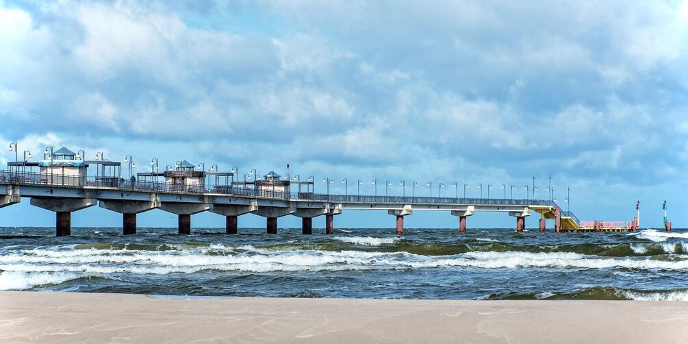 A long pier extending into the ocean with multiple levels and a lighthouse at the end. 3