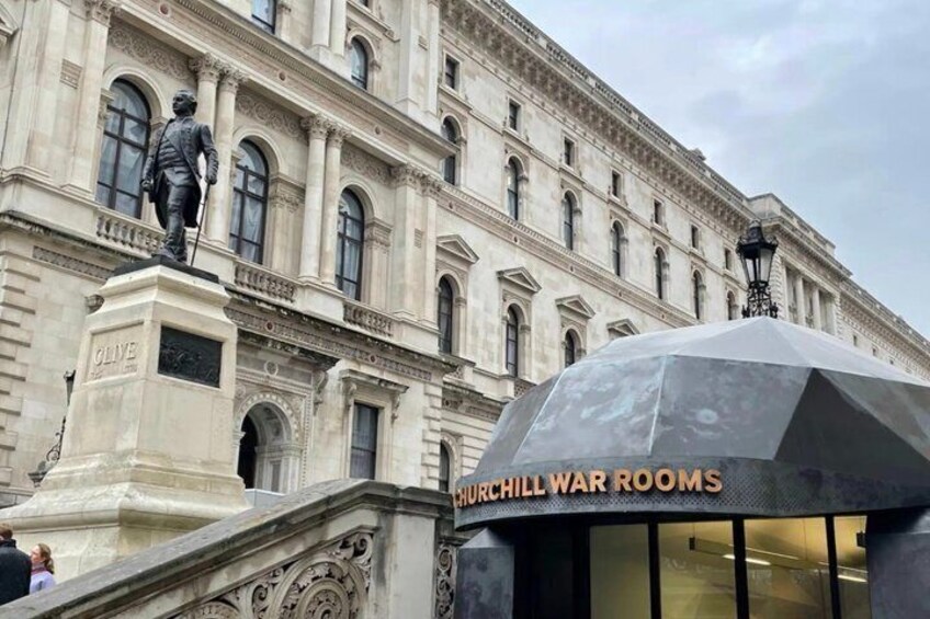 A historical building with a statue, a war room sign, and a covered entrance. 1