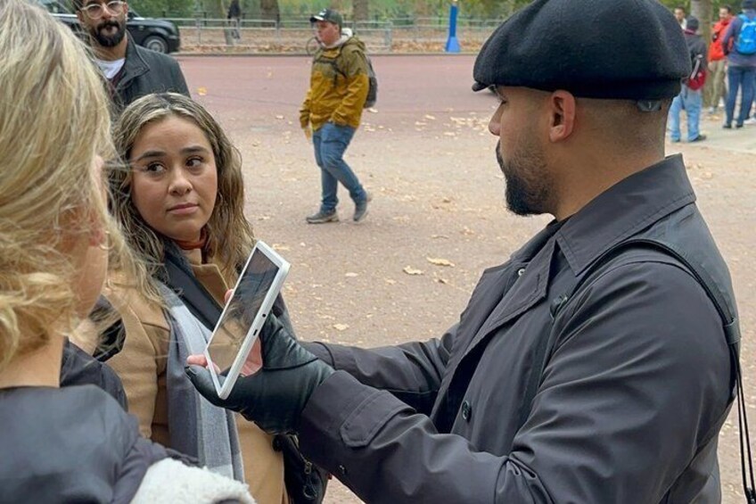 A person holding a tablet, another person with a blurred face, and a park with people in the background. 2