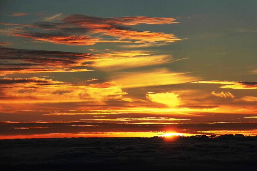 A sunset over a mountainous landscape with clouds. 1