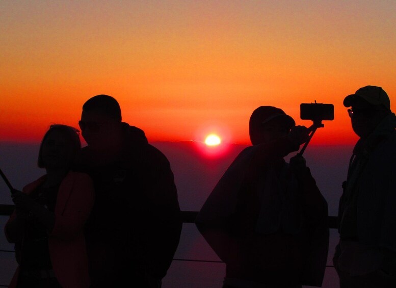 A sunset with silhouettes of people and a camera. 4