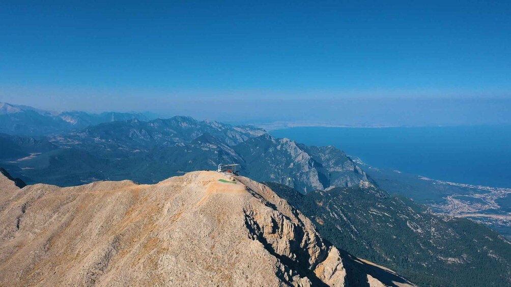 A mountainous landscape with a clear sky and a view of the sea in the distance. 5