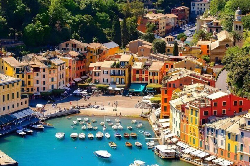 A coastal town with colorful buildings, a marina with boats, and a beach. 1