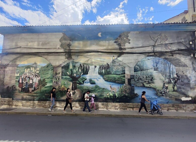 A mural with a waterfall, a person with arms raised, and a group of people. 5