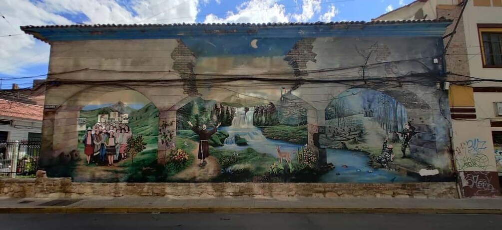A mural on a building depicting a landscape with a waterfall, trees, and people. 4