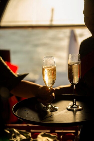 Two champagne glasses on a tray, held by a person. 4