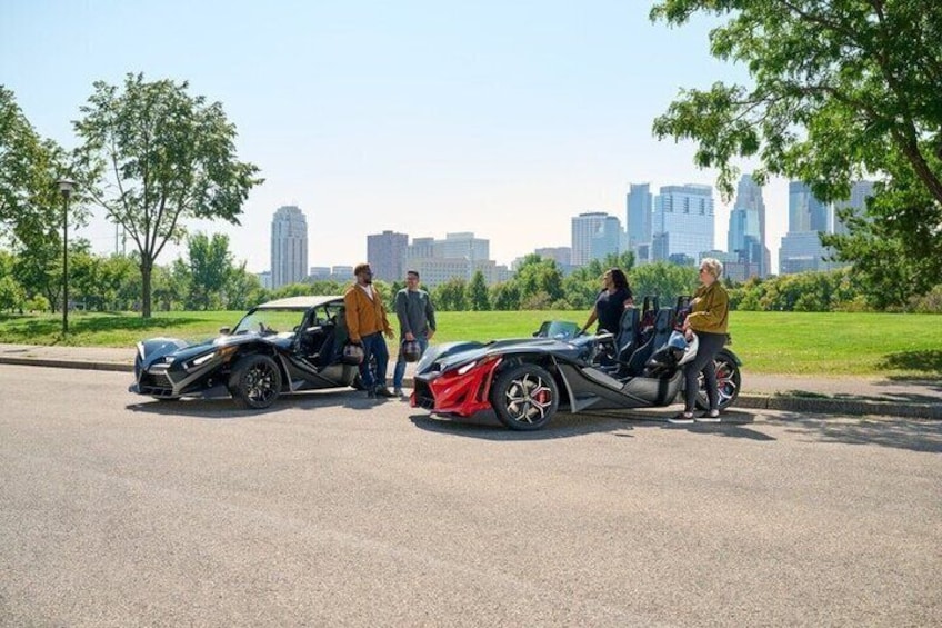 Two sports cars parked on a city street with a city skyline in the background. 4